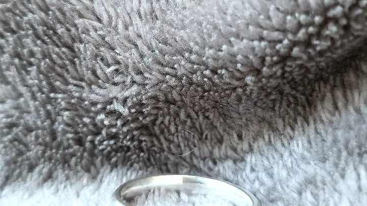 A domed silver band on a soft grey towel. (finished product)