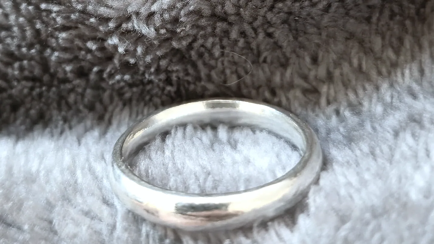 A heavy domed band, side on, catching a broad highlight. (finished product)